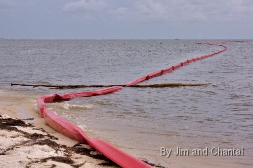  Log lies across boom deployed for BP oil spill with ship in background. Alligator Point: .